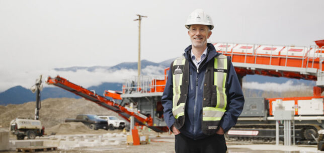 Mike Hofer stands in front of a soil cleaning plant