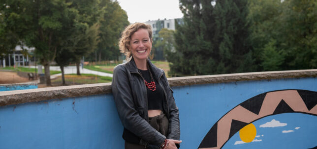 Kristine Lawson standing and smiling outside of UFV's dining hall.